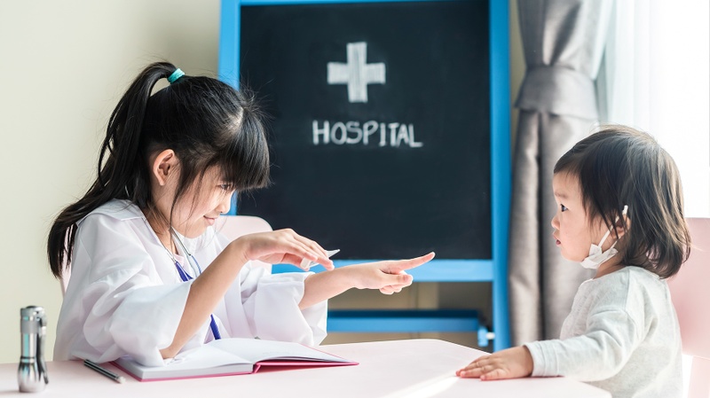 Zwei Mädchen spielen in der Spitalschule Patientin und Ärztin