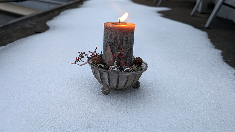 Brennende Kerze auf Schnee