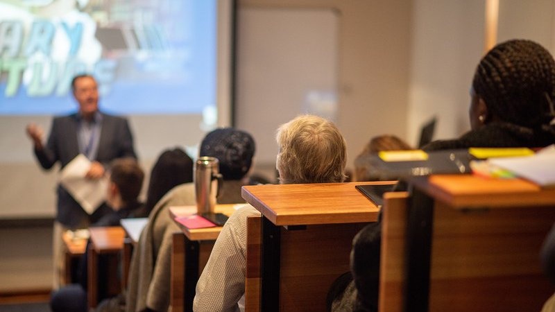 Hörsaal mit Studierenden und Dozent im Vordergrund