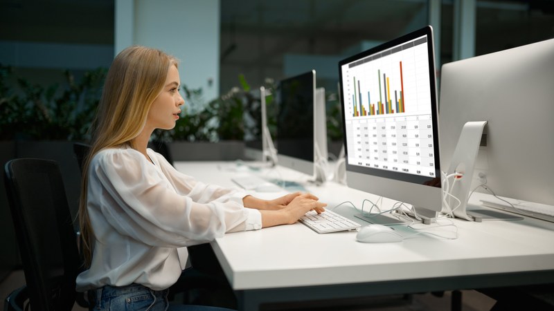 Une jeune femme crée des diagrammes à barres sur un ordinateur.