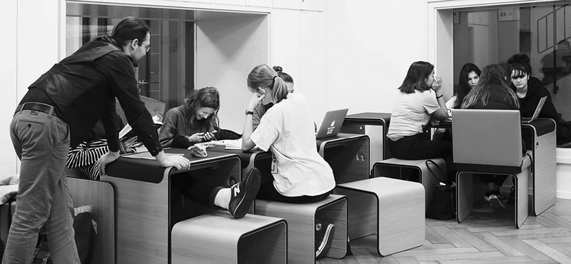 Des étudiants assis ensemble devant différents appareils électroniques