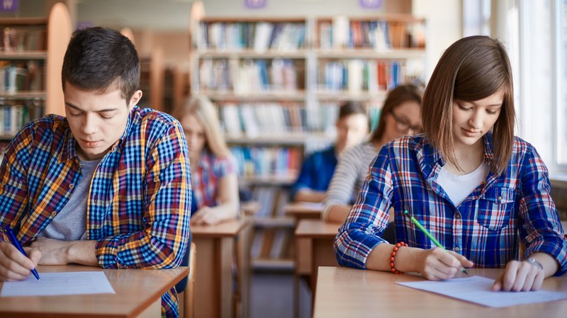 Deux adolescents passent un examen.